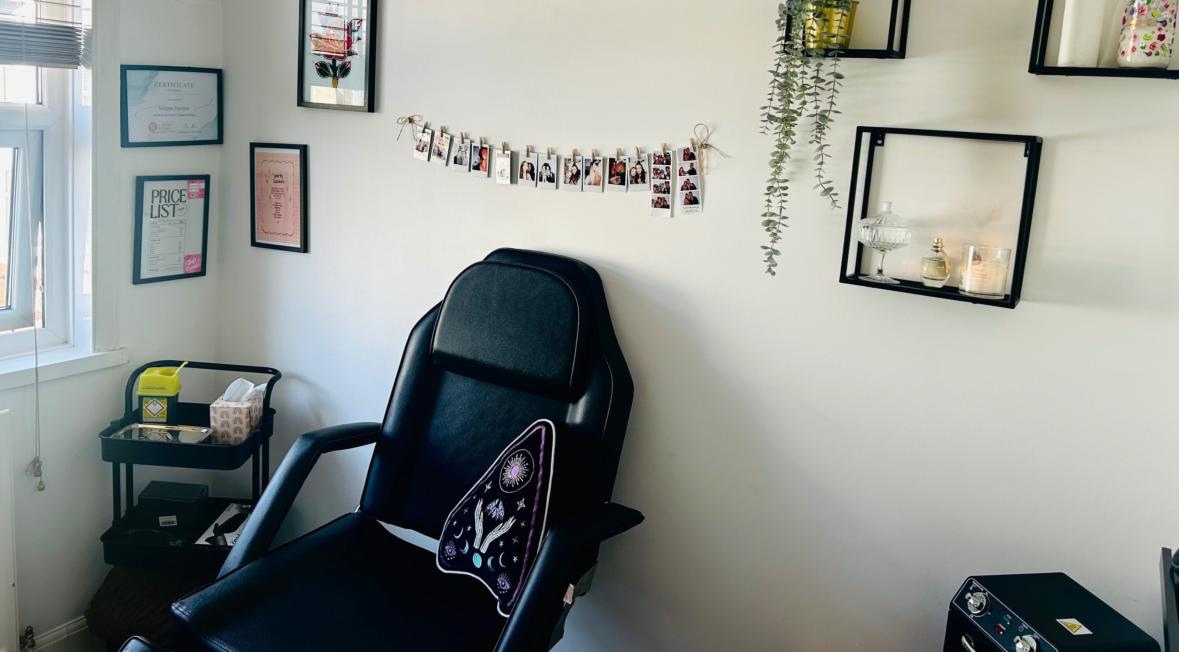 Chic piercing room at Durose Piercing, Portsmouth, England featuring a black chair and elegant wall decor.