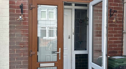 Front entrance of Durose Piercing in Portsmouth, England, GB featuring a modern wooden door.