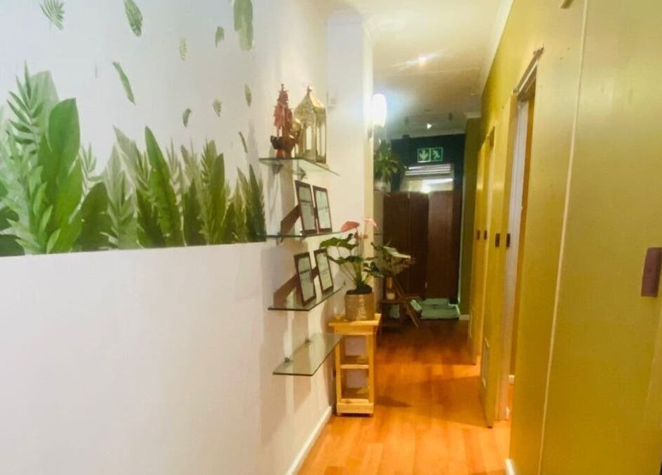 A tranquil hallway at Fadia Thai Massage, Cape Town, Western Cape, ZA, featuring lush greenery on walls.