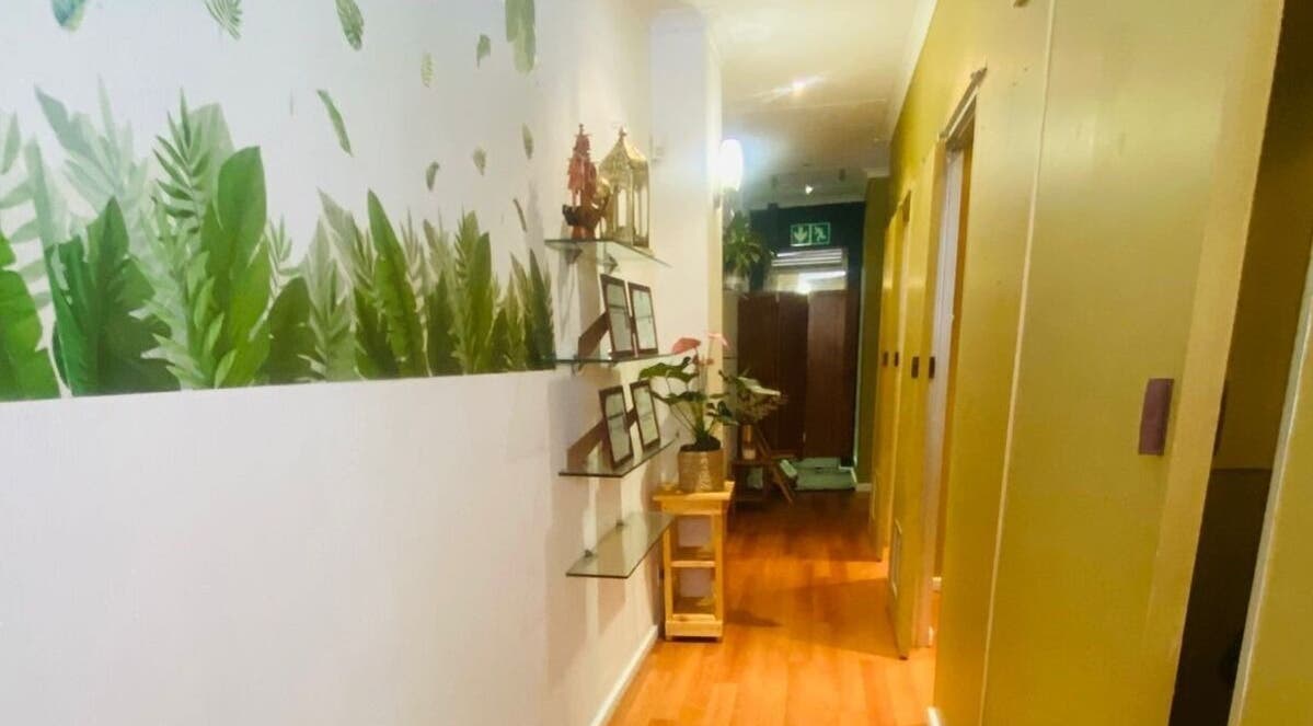 A tranquil hallway at Fadia Thai Massage, Cape Town, Western Cape, ZA, featuring lush greenery on walls.