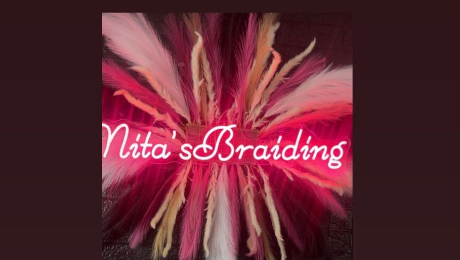 Vibrant neon sign with feathers at Nita's Braiding, Portsmouth, Saint John Parish, DM.