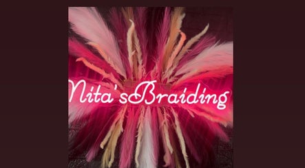 Vibrant neon sign with feathers at Nita's Braiding, Portsmouth, Saint John Parish, DM.