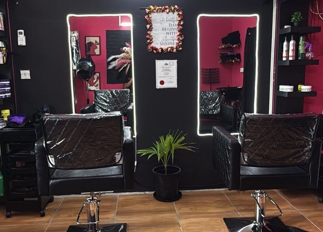 Modern salon interior at Nita’s Braiding, Portsmouth, Saint John Parish, DM, featuring stylish black chairs and mirrors.