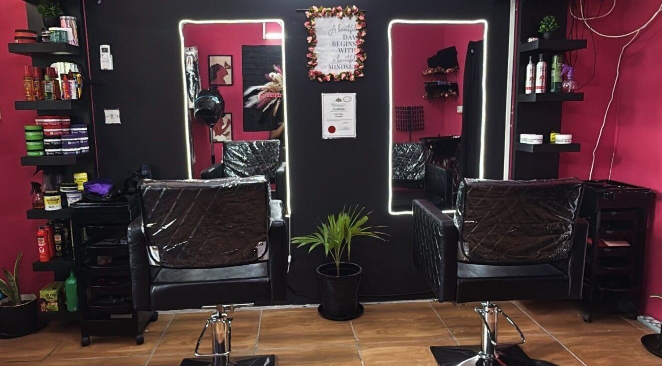 Modern salon interior at Nita’s Braiding, Portsmouth, Saint John Parish, DM, featuring stylish black chairs and mirrors.