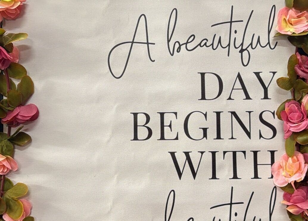 Inspirational wall art with pink flowers at Nita’s Braiding, Portsmouth, Saint John Parish, DM.