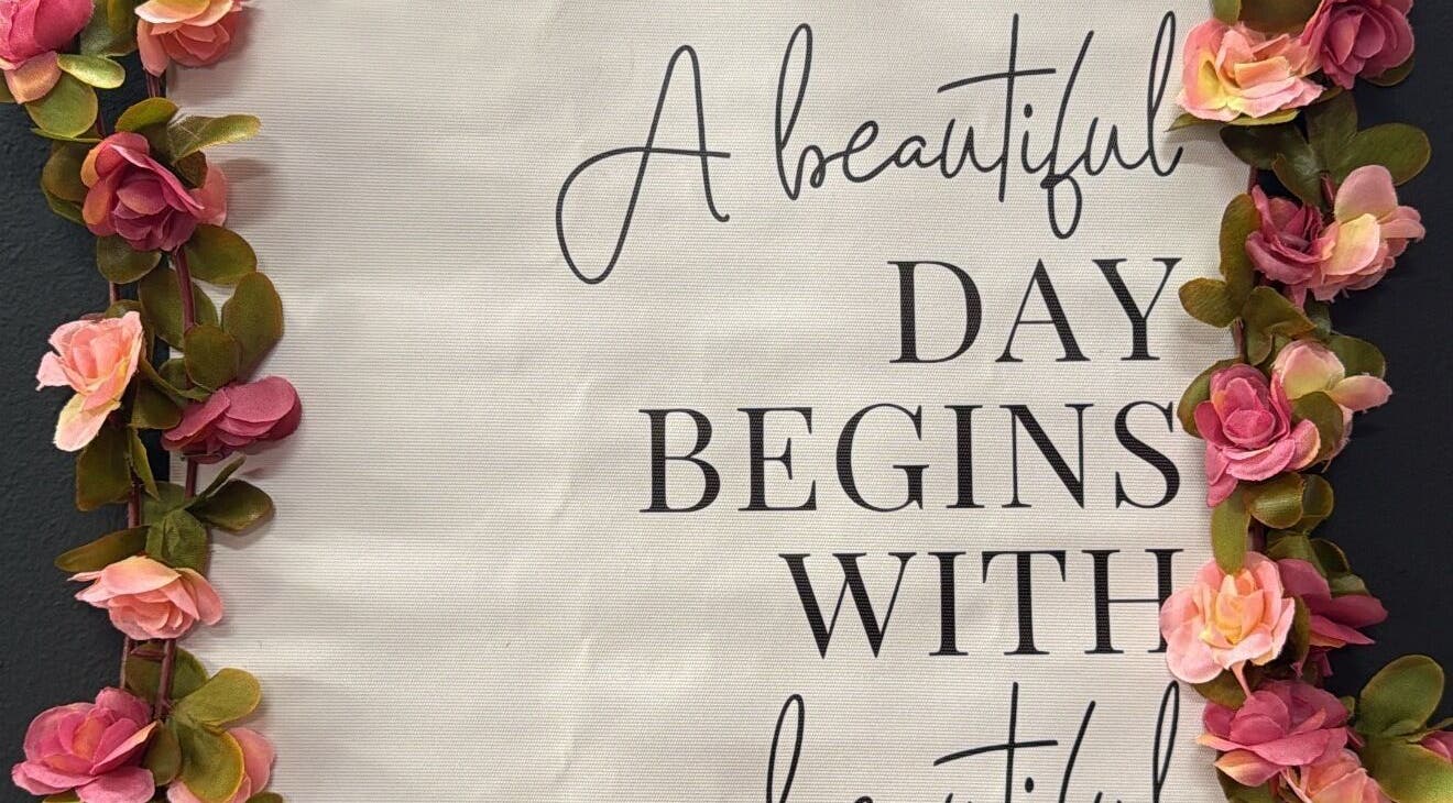 Inspirational wall art with pink flowers at Nita’s Braiding, Portsmouth, Saint John Parish, DM.