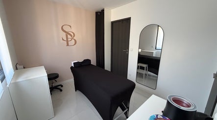 Salle de soins élégante chez Simplement Belle, Cournonterral, Occitanie, FR, avec table de massage noire.