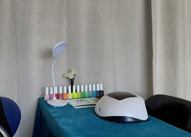 Modern nail station at Nails By Shaaquila, Roodepoort, Gauteng, ZA, with colorful polishes and UV lamp.