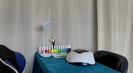 Modern nail station at Nails By Shaaquila, Roodepoort, Gauteng, ZA, with colorful polishes and UV lamp.