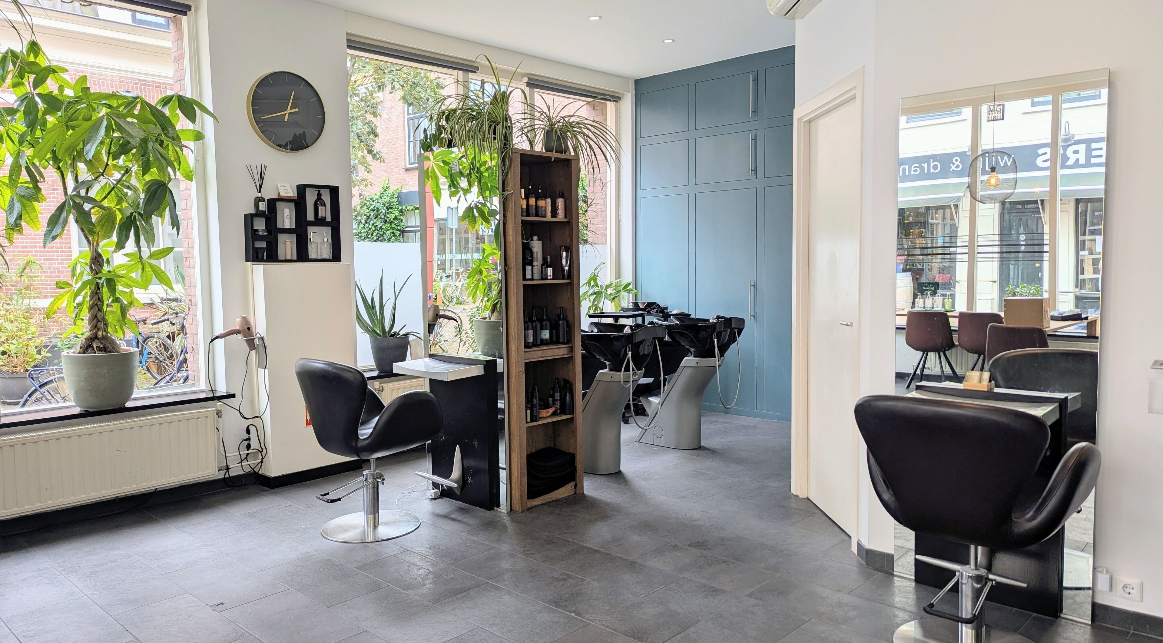 Moderne interieur van Mixt Styling Haarlem Centrum, Haarlem, Noord-holland, NL met kappersstoelen en planten.