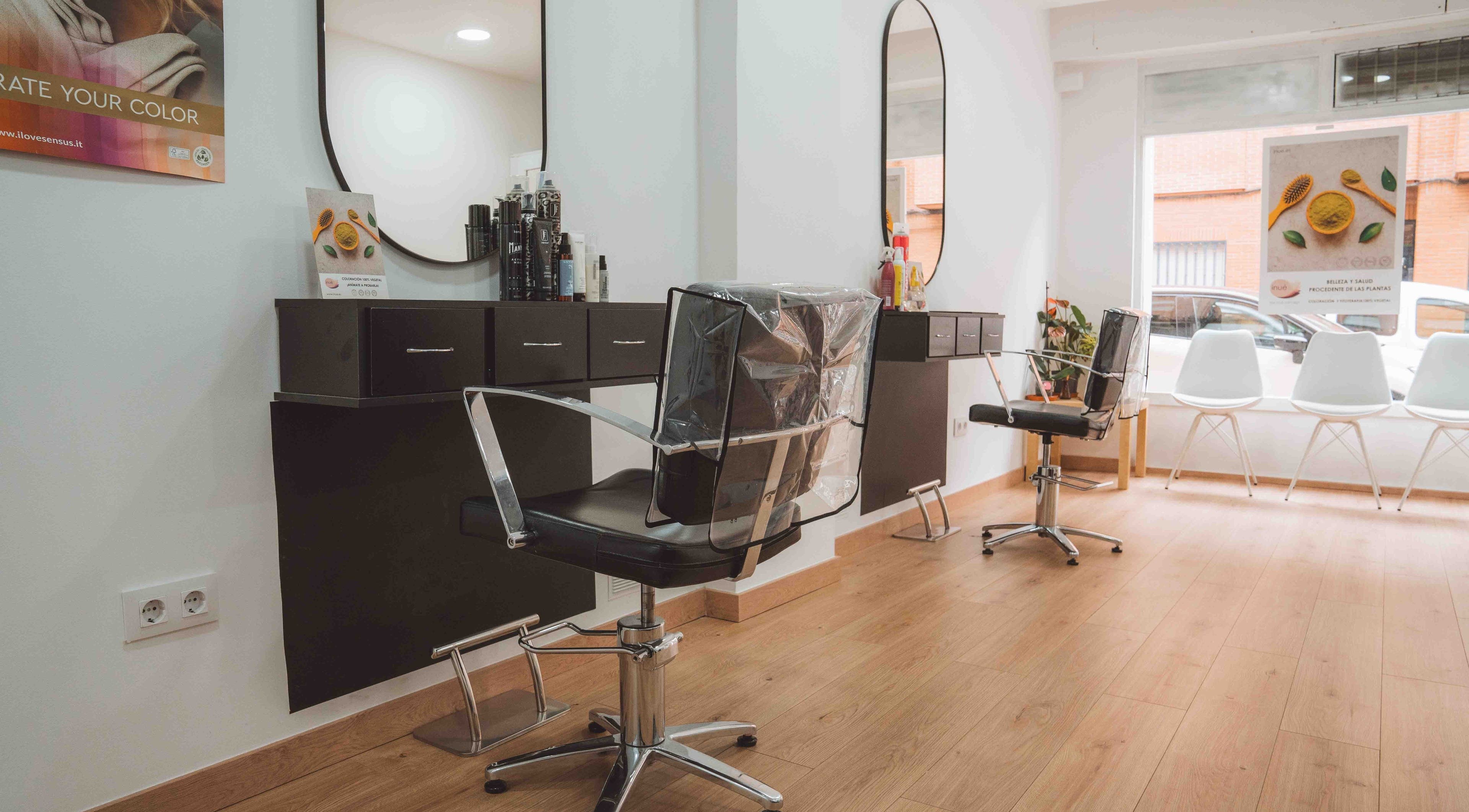 Moderno salón de M'AS PELUQUEROS en Madrid, Comunidad De Madrid, ES, con sillas elegantes y espejos ovalados.