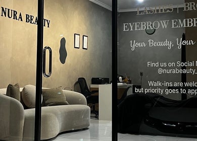 Interior elegan Nura Beauty Studio di Bali, Bali, ID, menampilkan sofa nyaman dan dekorasi estetis.