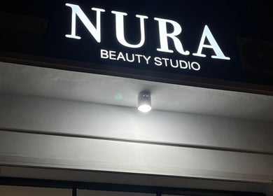 Tampilan luar Nura Beauty Studio di Bali, Bali, ID saat malam dengan pencahayaan neon yang menarik.