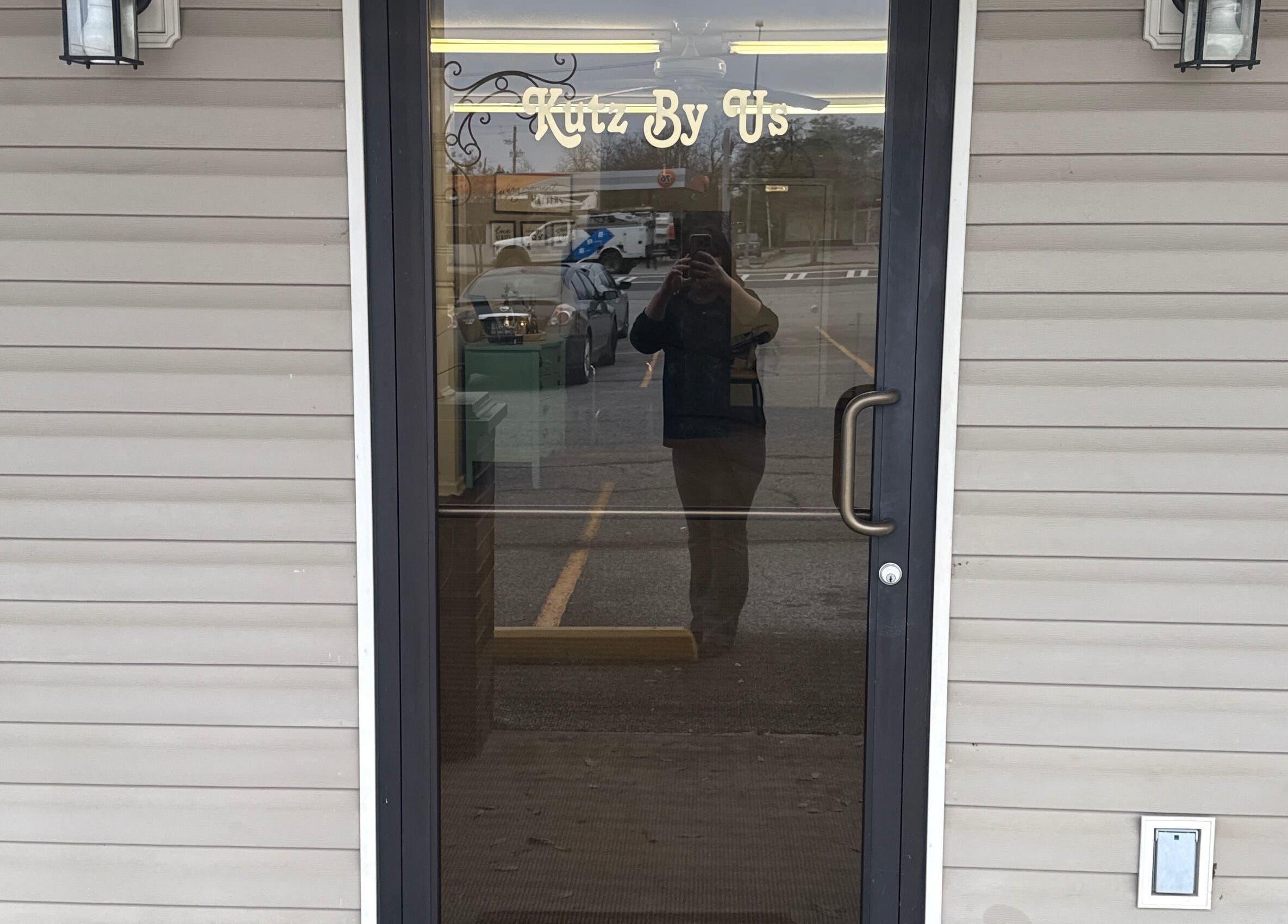 Front door of Kutz By Us in Thomaston, Georgia, US, showcasing elegant signage and inviting entrance.