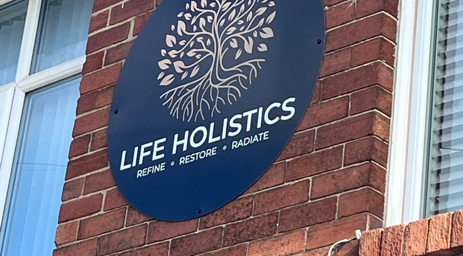 Life Holistics sign on brick wall, North Shields, England, GB.