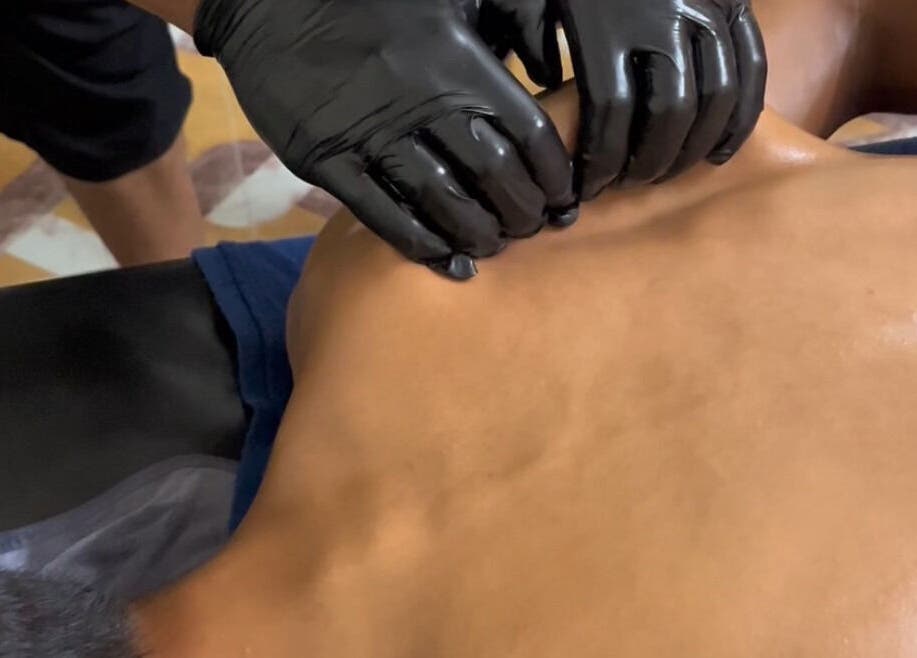 Therapist at MAMU MASSAGE in Shah Alam, Selangor, MY performing back massage with black gloves.