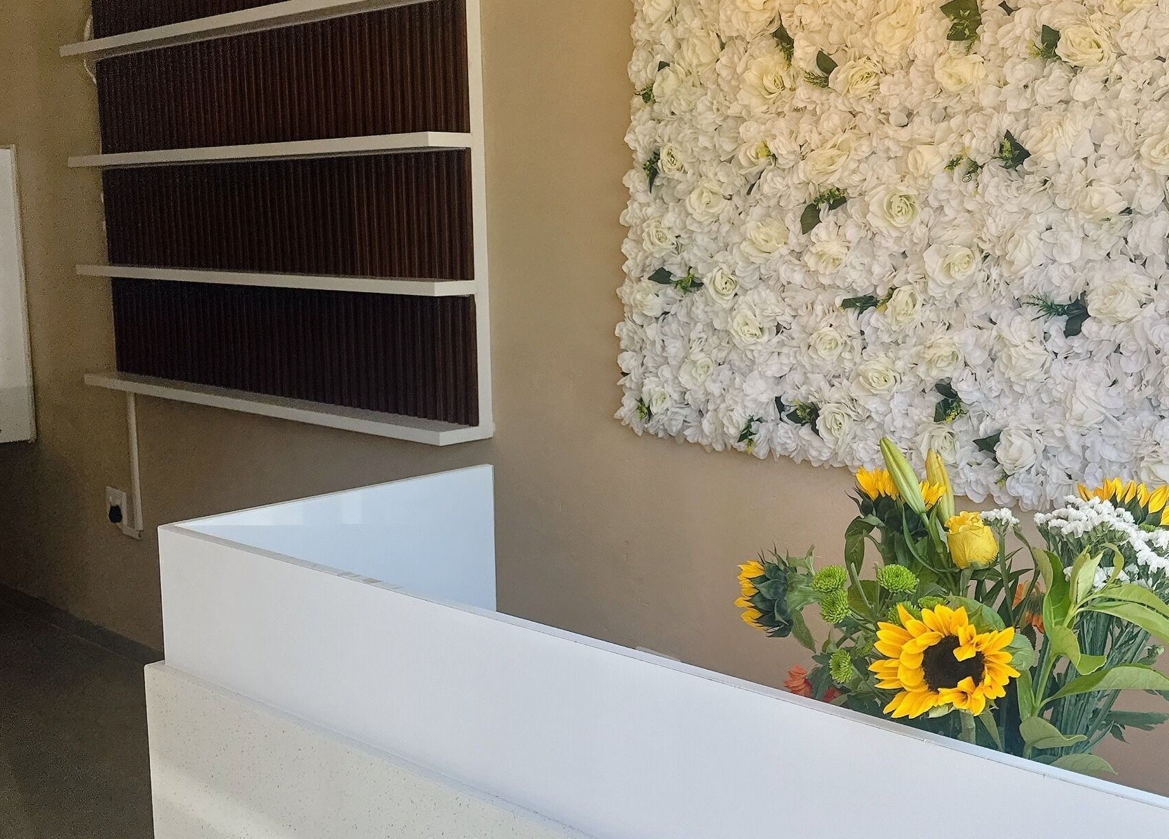 Elegant reception with floral wall at BU Aesthetics in Benoni, Gauteng, ZA offering a warm welcome.
