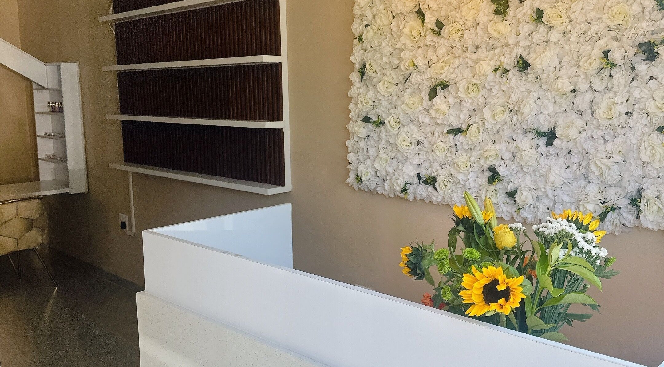 Elegant reception with floral wall at BU Aesthetics in Benoni, Gauteng, ZA offering a warm welcome.