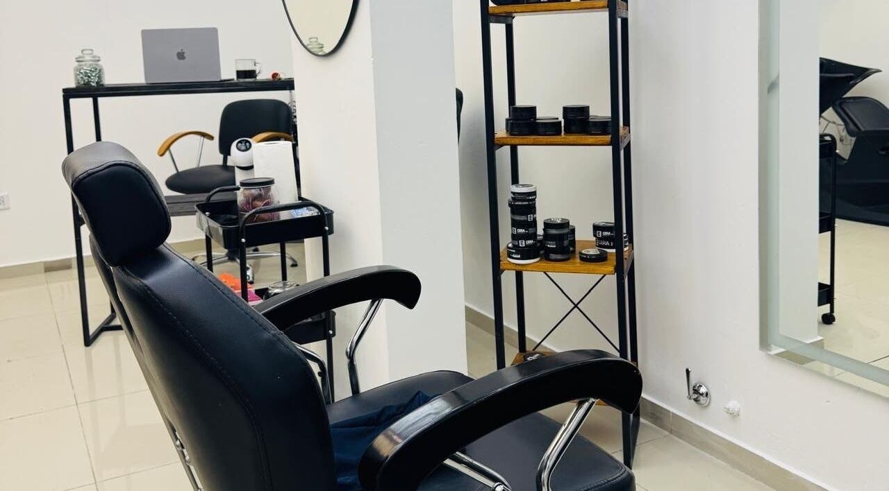 Interior de Kanso Studio en Rosario, Santa Fe, AR: silla de peluquería y estantería con productos.