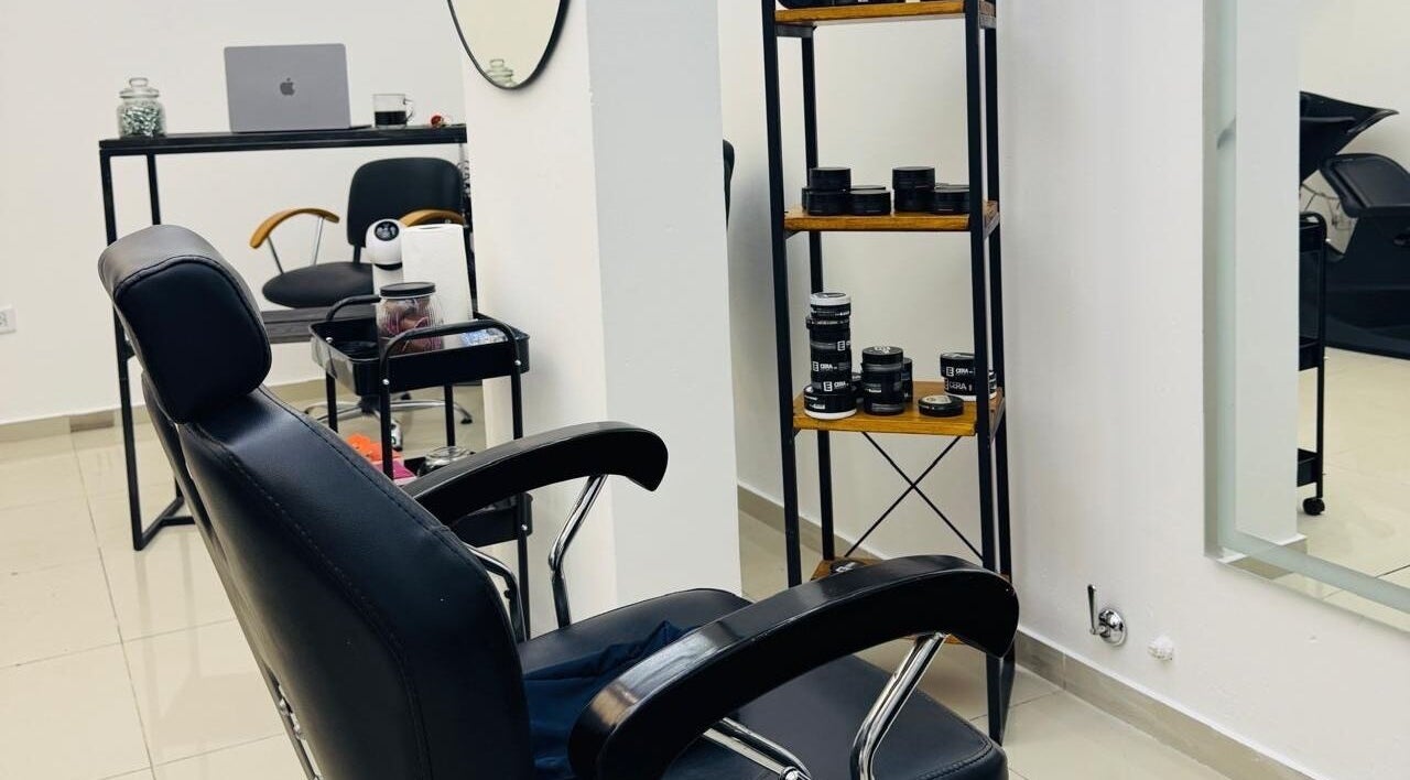 Interior de Kanso Studio en Rosario, Santa Fe, AR: silla de peluquería y estantería con productos.