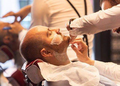 Client receiving a professional shave at Ted's Grooming Room: Baker Street - Dorset Street in London, England, GB.