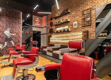 Modern interior of Ted's Grooming Room: Westfield - Stratford in London, England, GB with red barber chairs.