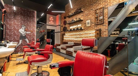 Modern interior of Ted's Grooming Room: Westfield - Stratford in London, England, GB with red barber chairs.