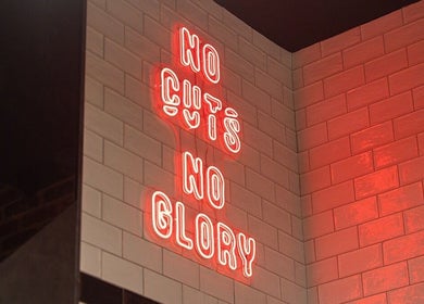 Neon sign 'No Cuts No Glory' at Ted's Grooming Room: Westfield - Stratford, London, England, GB.