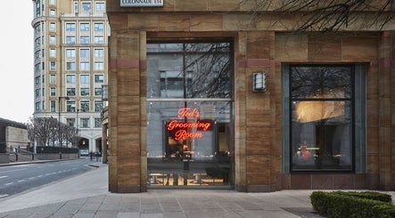 Exterior view of Ted's Grooming Room: Canary Wharf - Cabot Place, London, England, GB with glowing signage.