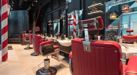 Sleek red barber chairs and mirrors at Ted's Grooming Room: Liverpool Street - Tower 42, London, England, GB.
