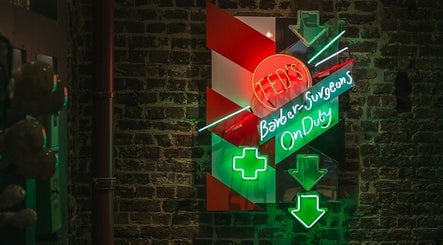 Neon sign at Mortimer Street - Regents, Ted's Grooming Room in London, England, GB on a brick wall.