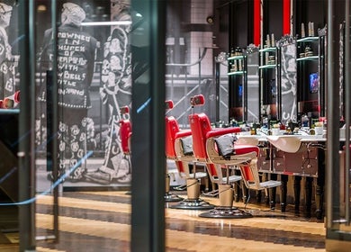 Stylish barbershop interior with red chairs at One New Change - Bank, Ted's Grooming Room, London, England, GB.