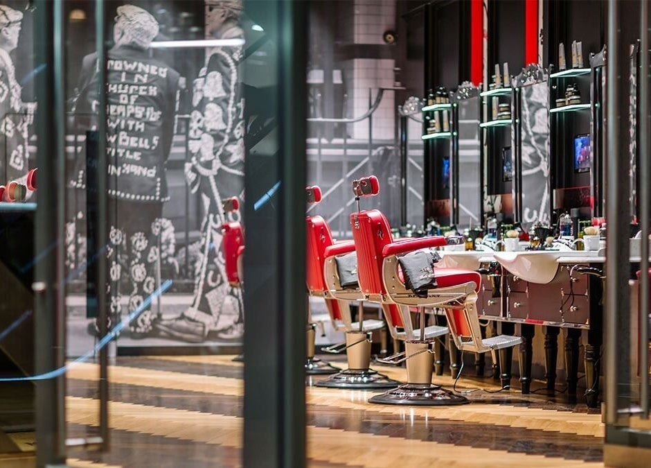 Stylish barbershop interior with red chairs at One New Change - Bank, Ted's Grooming Room, London, England, GB.