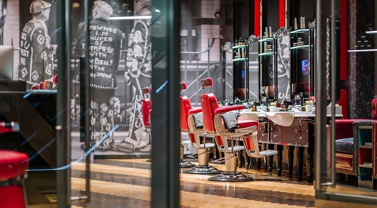 Stylish barbershop interior with red chairs at One New Change - Bank, Ted's Grooming Room, London, England, GB.