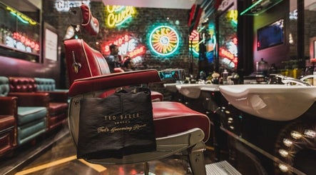 Interior of Berwick Street Ted's Grooming Room, London, showcasing a vintage barber chair and neon signs.