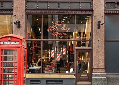 Exterior of Ted's Grooming Room, Strand - The Strand, London, England, GB with iconic red phone booths.