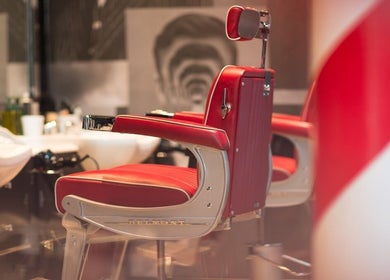 Barber chair at Tower 42 - Liverpool Street, Ted's Grooming Room, London, England, GB with red vintage style.
