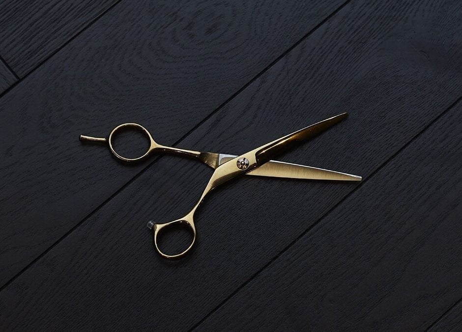 Elegant golden scissors on black wood at Cabot Place - Canary Wharf, Ted's Grooming Room, London, England, GB.