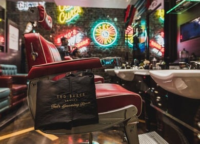 Retro barbershop interior at Soho - Berwick Street, Ted's Grooming Room, London, England, GB with neon signs.