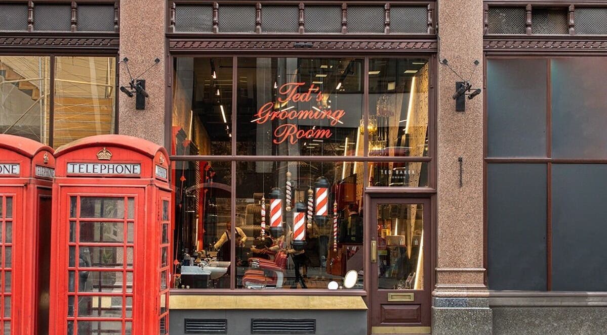 Front view of Ted's Grooming Room at Strand, London, England, GB with iconic red telephone boxes.