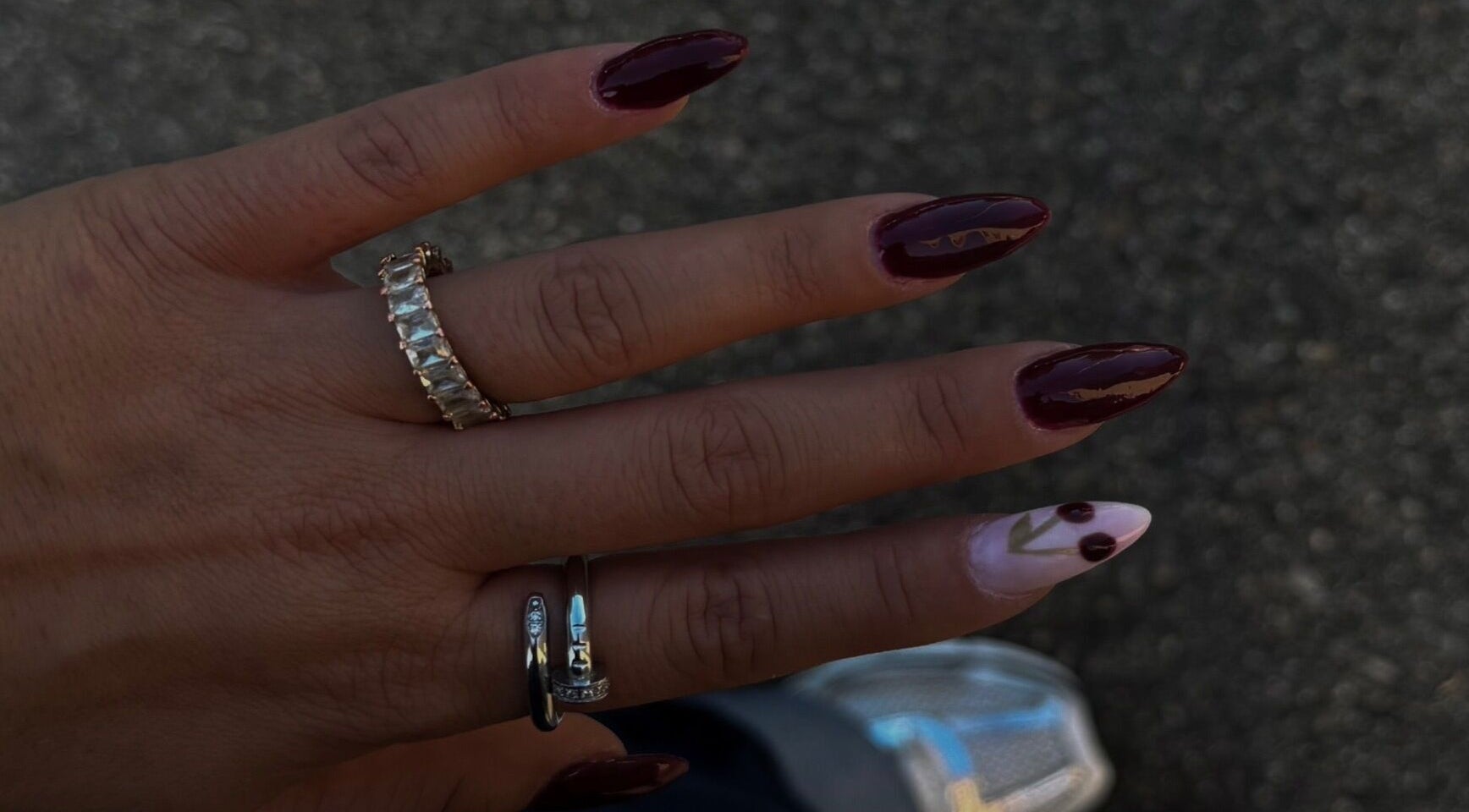 Elegant nail art showcased by Zanéa Beauty, Arbon, Thurgau, CH featuring burgundy and floral pattern.