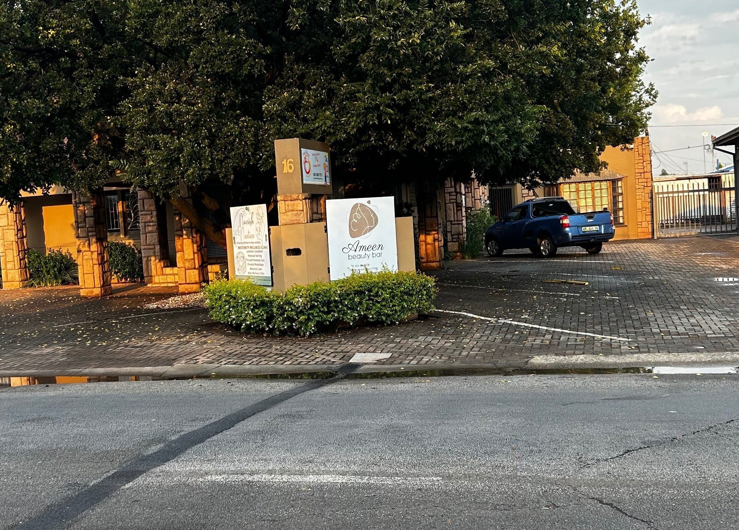 A scenic view of the @PALACE entrance with lush greenery in Potchefstroom, North West, ZA.