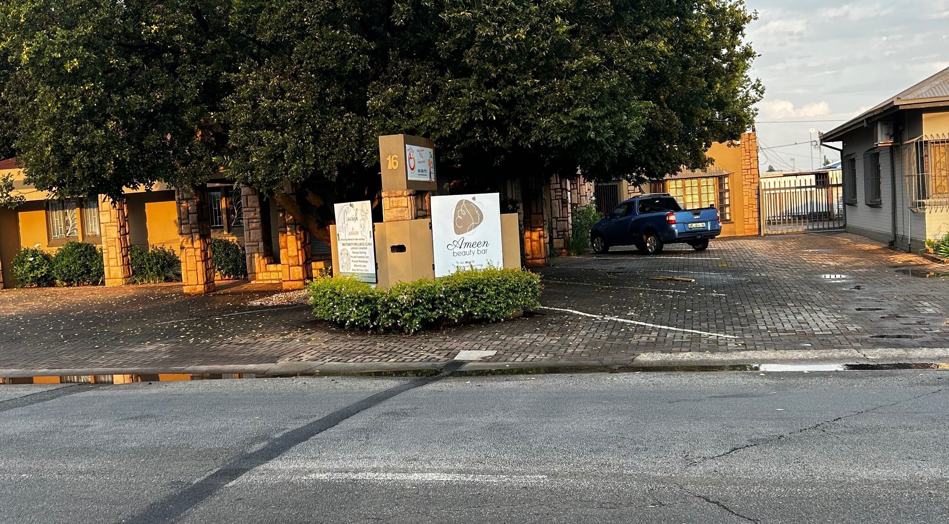 A scenic view of the @PALACE entrance with lush greenery in Potchefstroom, North West, ZA.