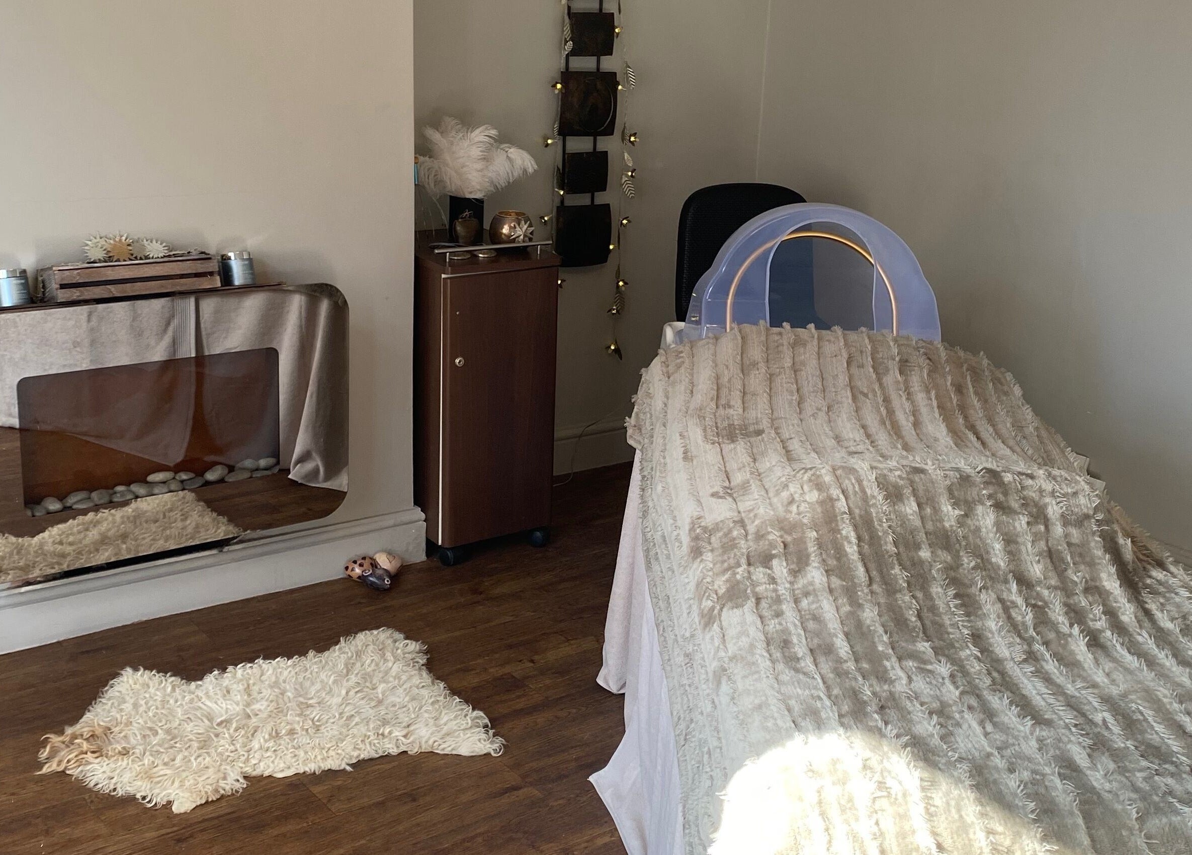 A serene treatment room at The Skin Refinery, Birmingham, England, GB, with a cushioned bed and elegant decor.