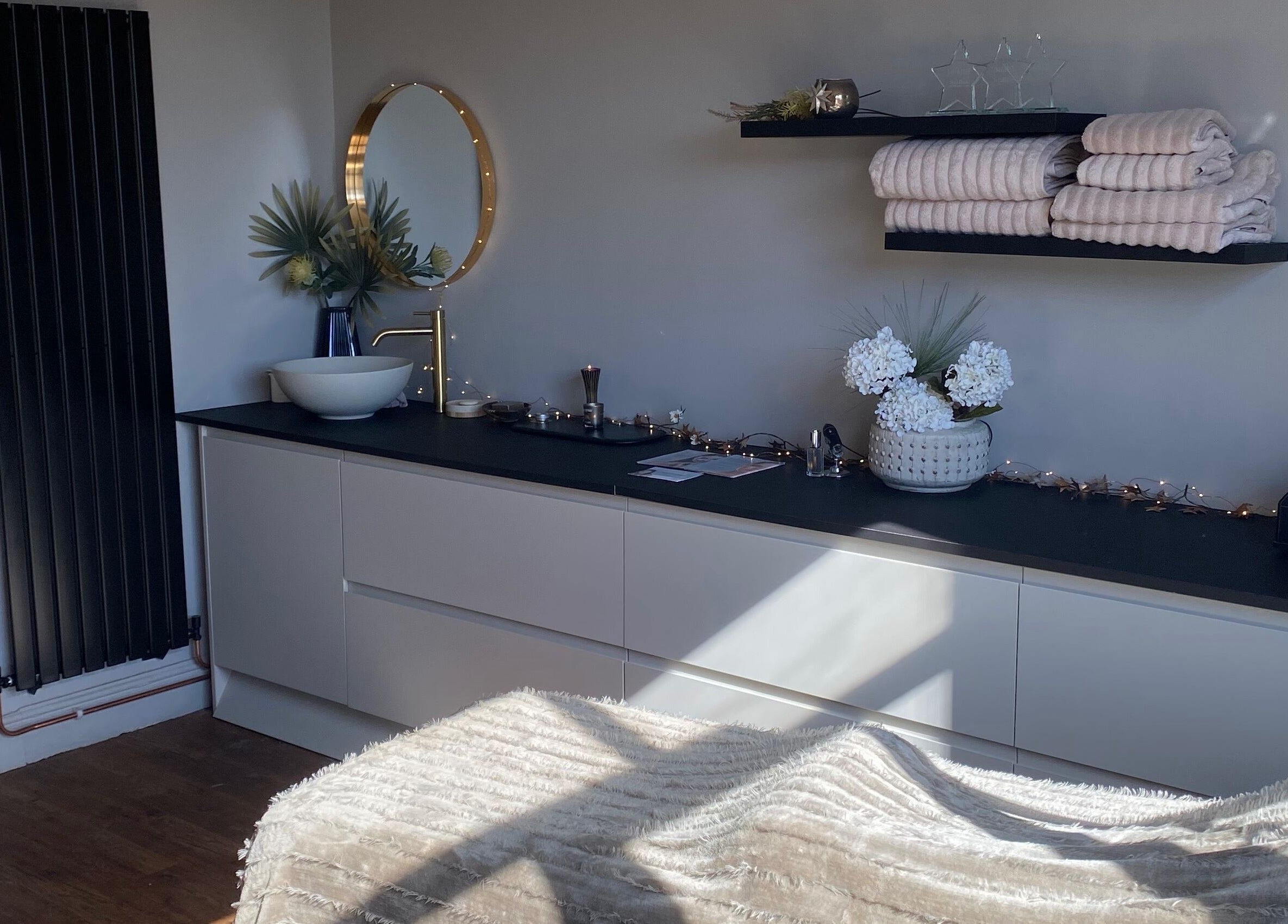 Modern treatment room at The Skin Refinery, Birmingham, England, featuring plush towels and chic decor.