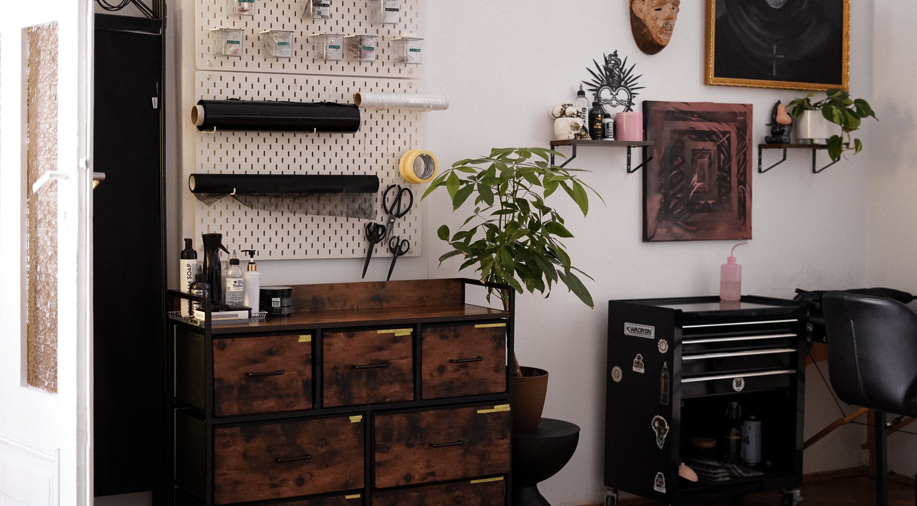 Artystyczne wnętrze Somah Tattoo & Piercing, Warszawa, Województwo Mazowieckie, PL z rośliną i narzędziami.