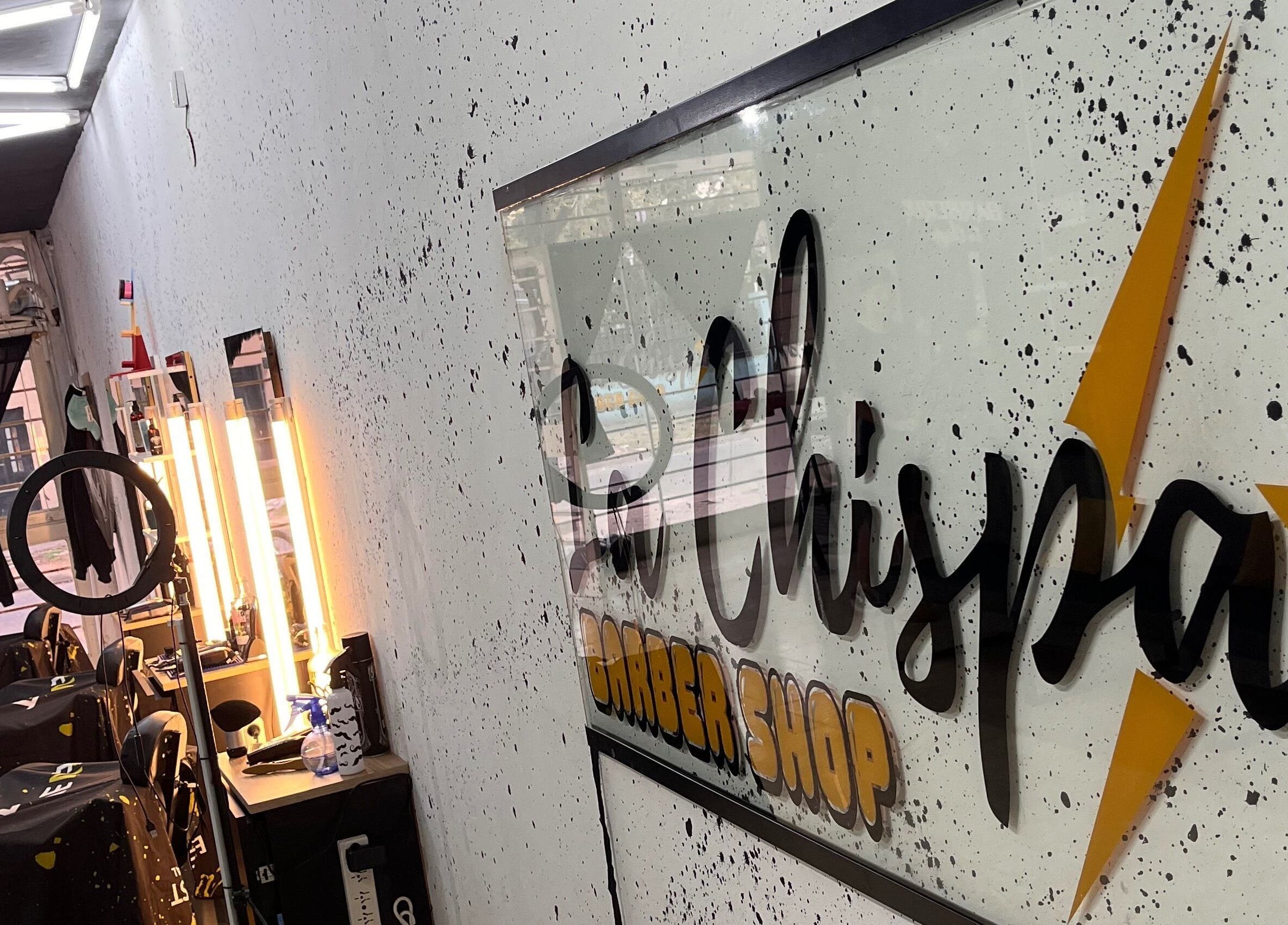 Interior of Barbería La Chispa, Rosario, Santa Fe, AR, showcasing modern lighting and sleek barber stations.