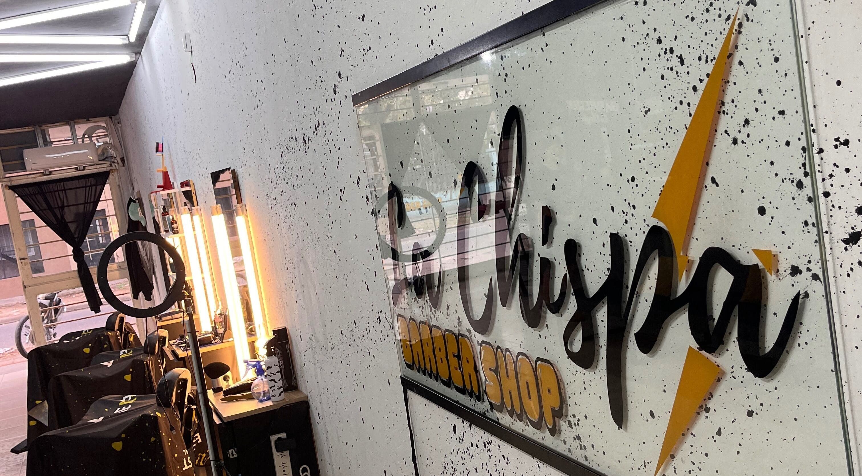 Interior of Barbería La Chispa, Rosario, Santa Fe, AR, showcasing modern lighting and sleek barber stations.