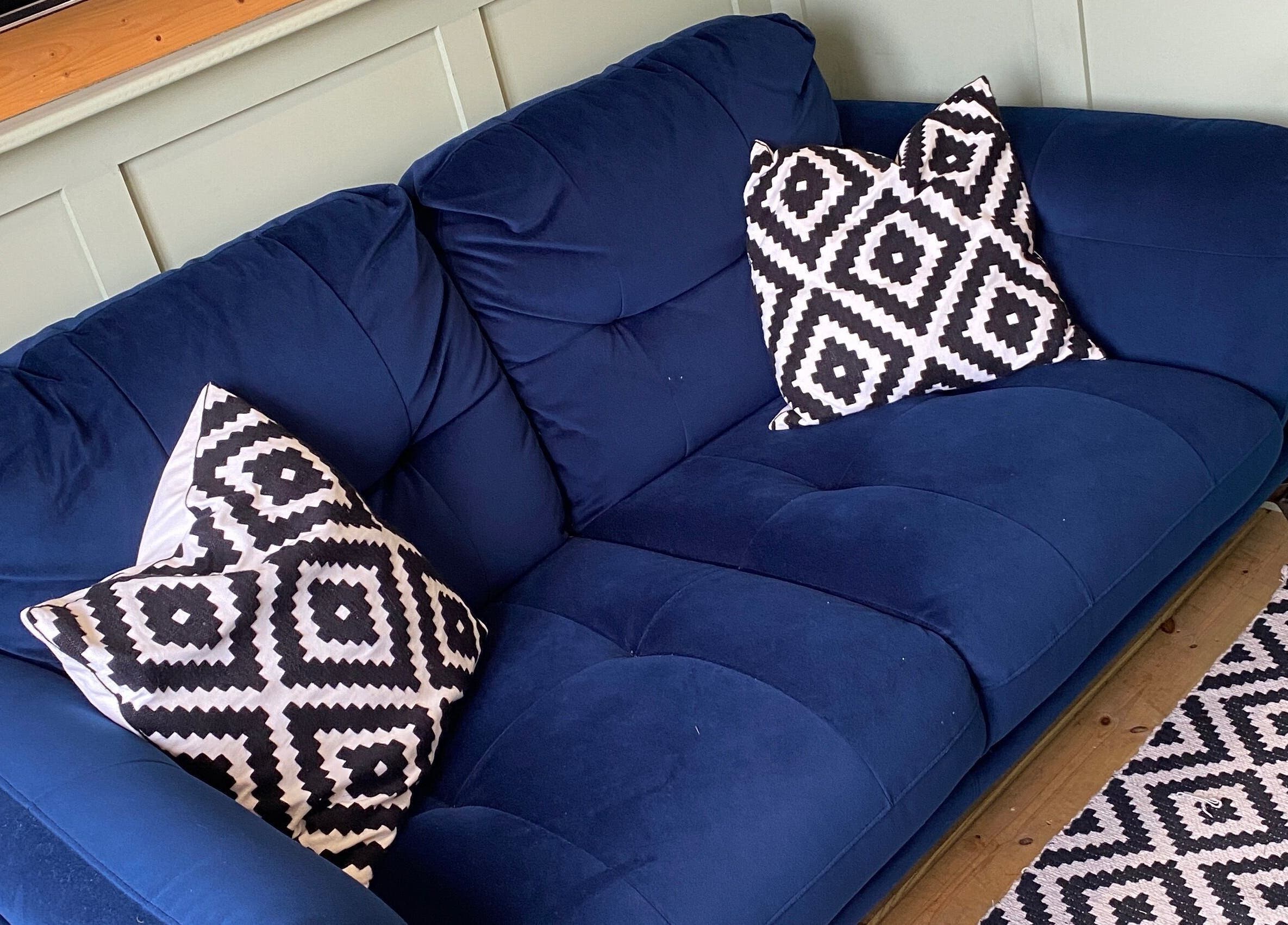 Stylish blue couch with patterned pillows at House of Wax | Waxing Salon, St Helens, England, GB.