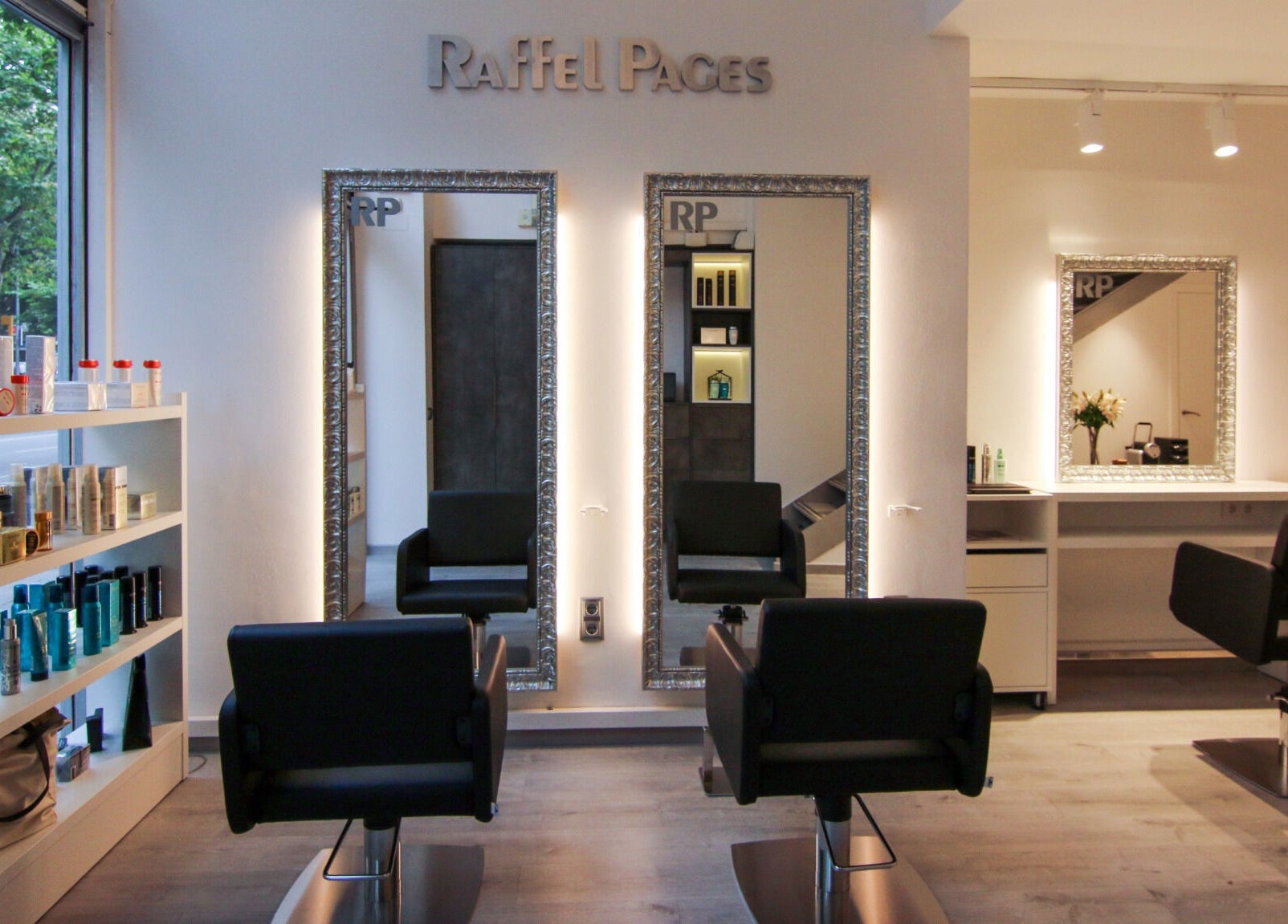 Elegante salón en Raffel Pages Provença, Barcelona, Catalunya, ES, con sillas negras y estantes de productos.